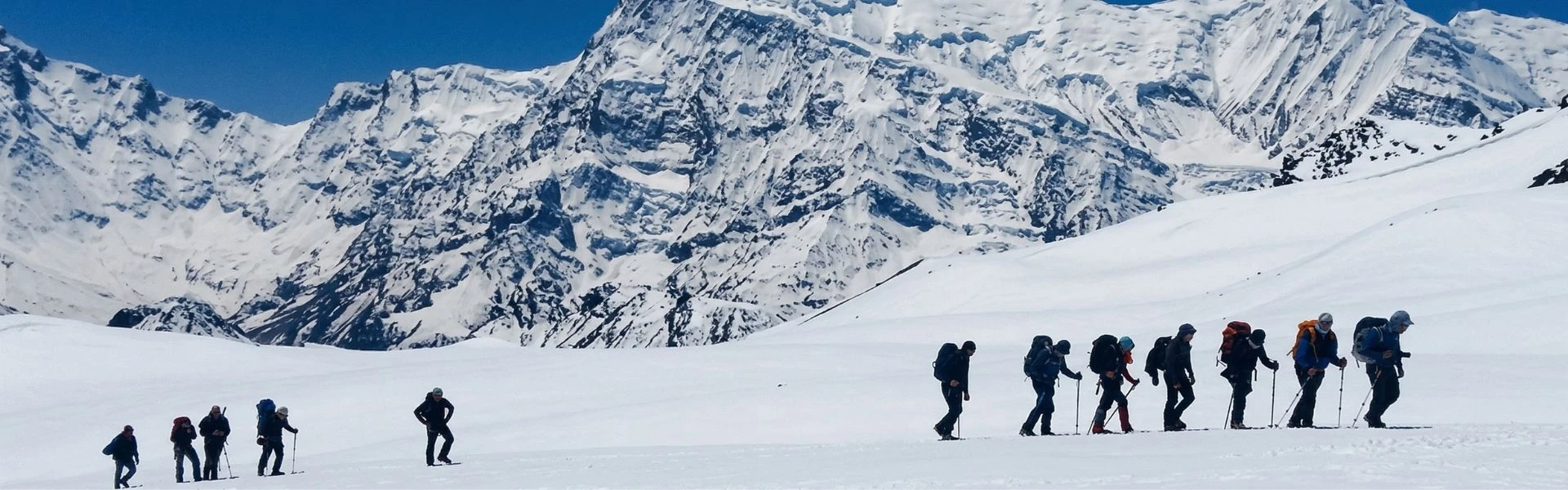 Alpinistes marchant vers le sommet du Chulu East avec vue sur les montagnes de l’Annapurna.