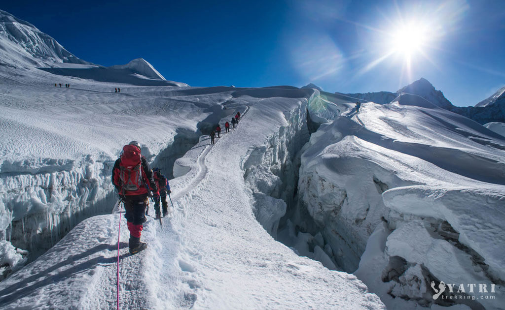 Alpiniste gravissant l’Island Peak au Népal avec vue sur l’Himalaya