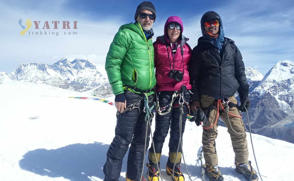 Trekkers et guides fêtant leur réussite au sommet du Mera Peak dans l’Himalaya